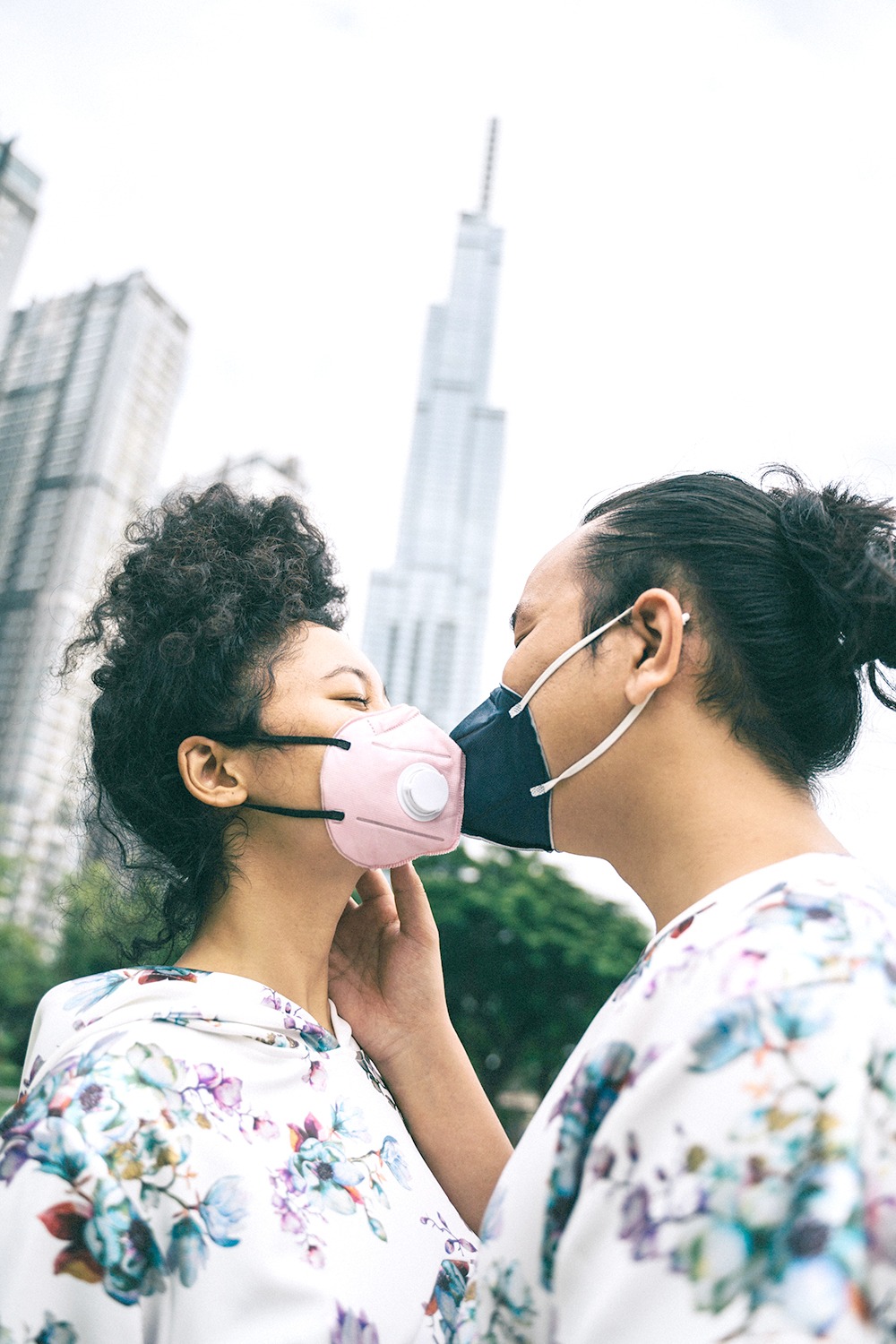 Couple wearing face masks imitating a kiss