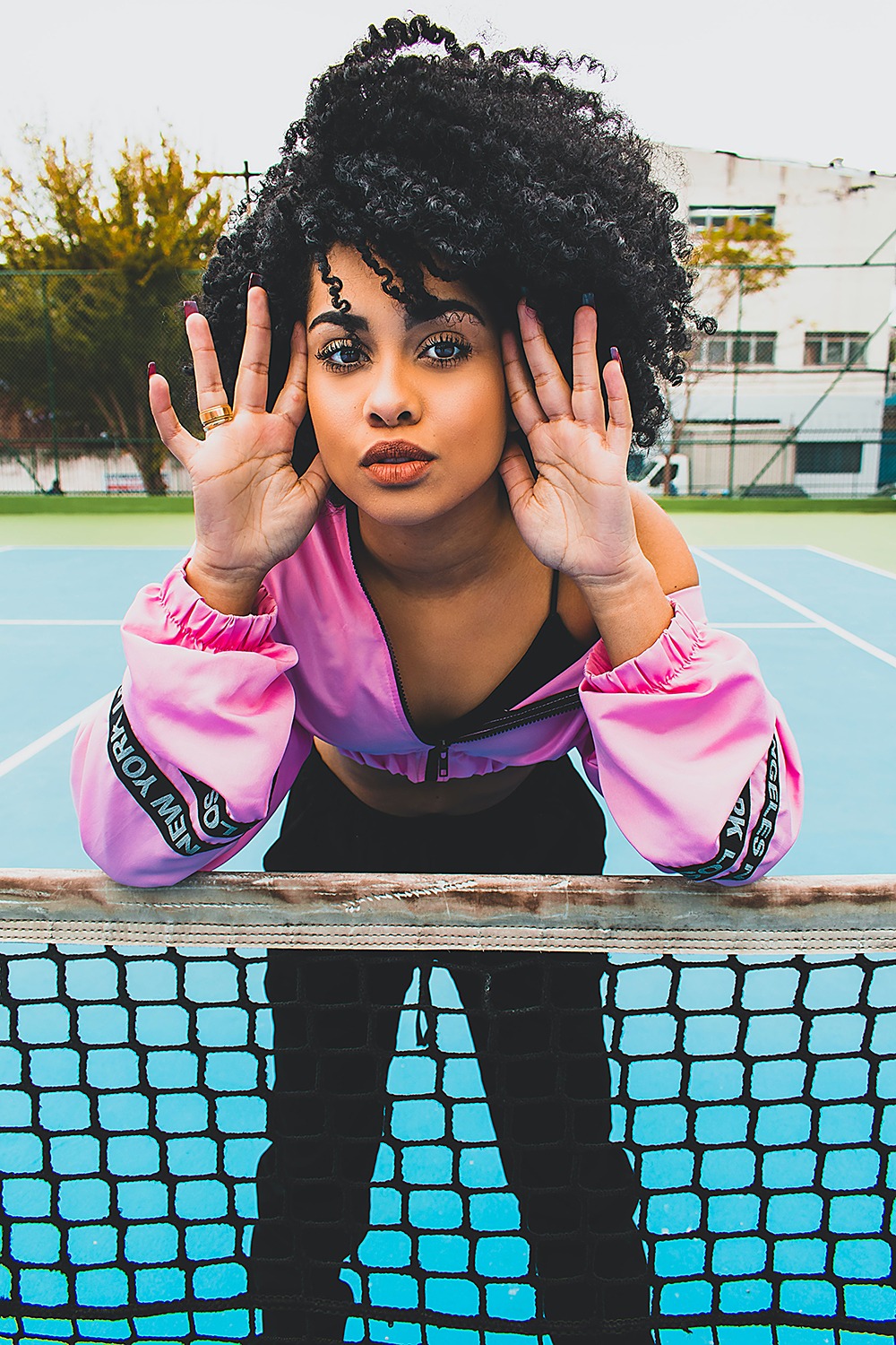 woman in sports jumper in a tennis court.