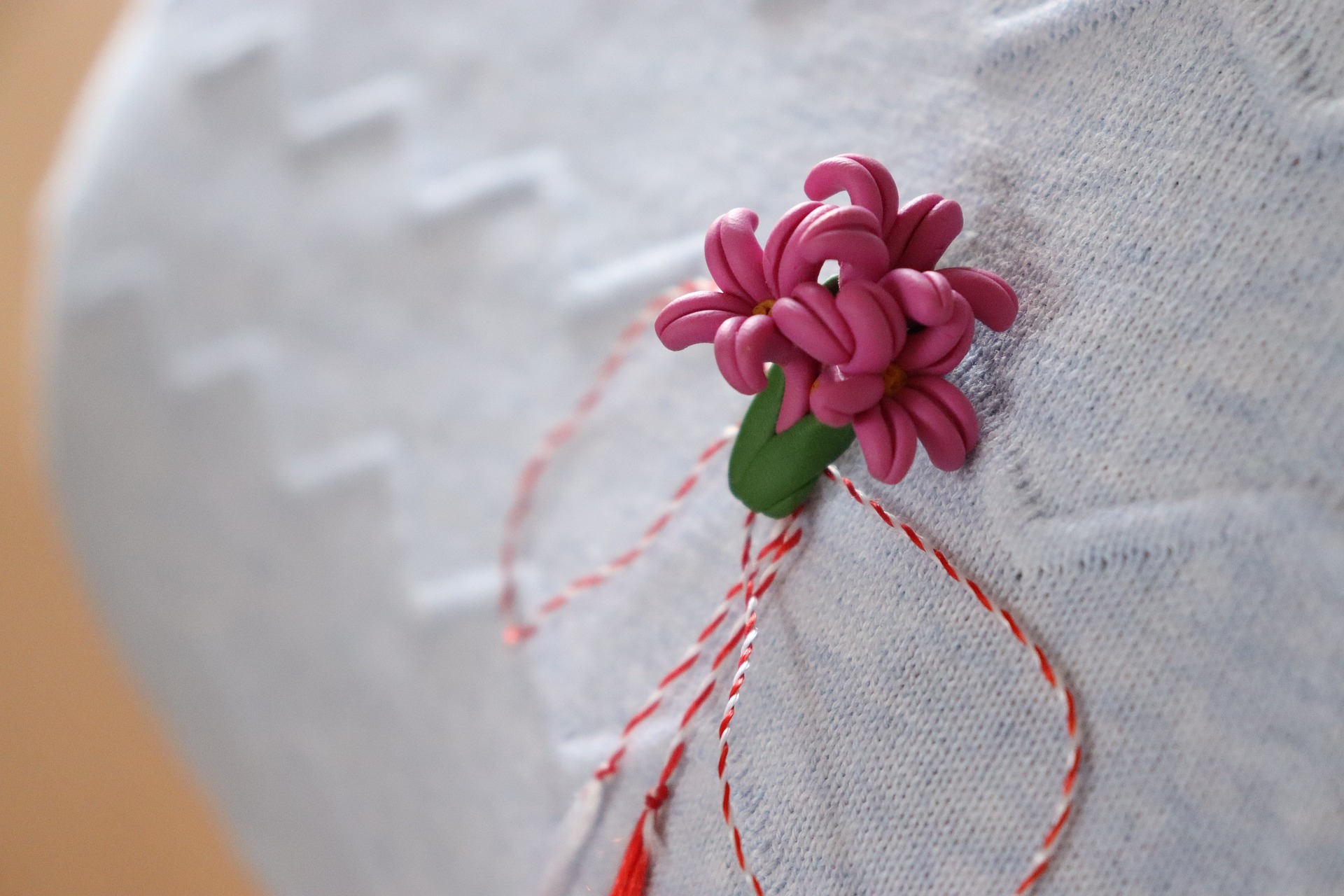 woman's hands with polished nails in coral color on a beach towel
