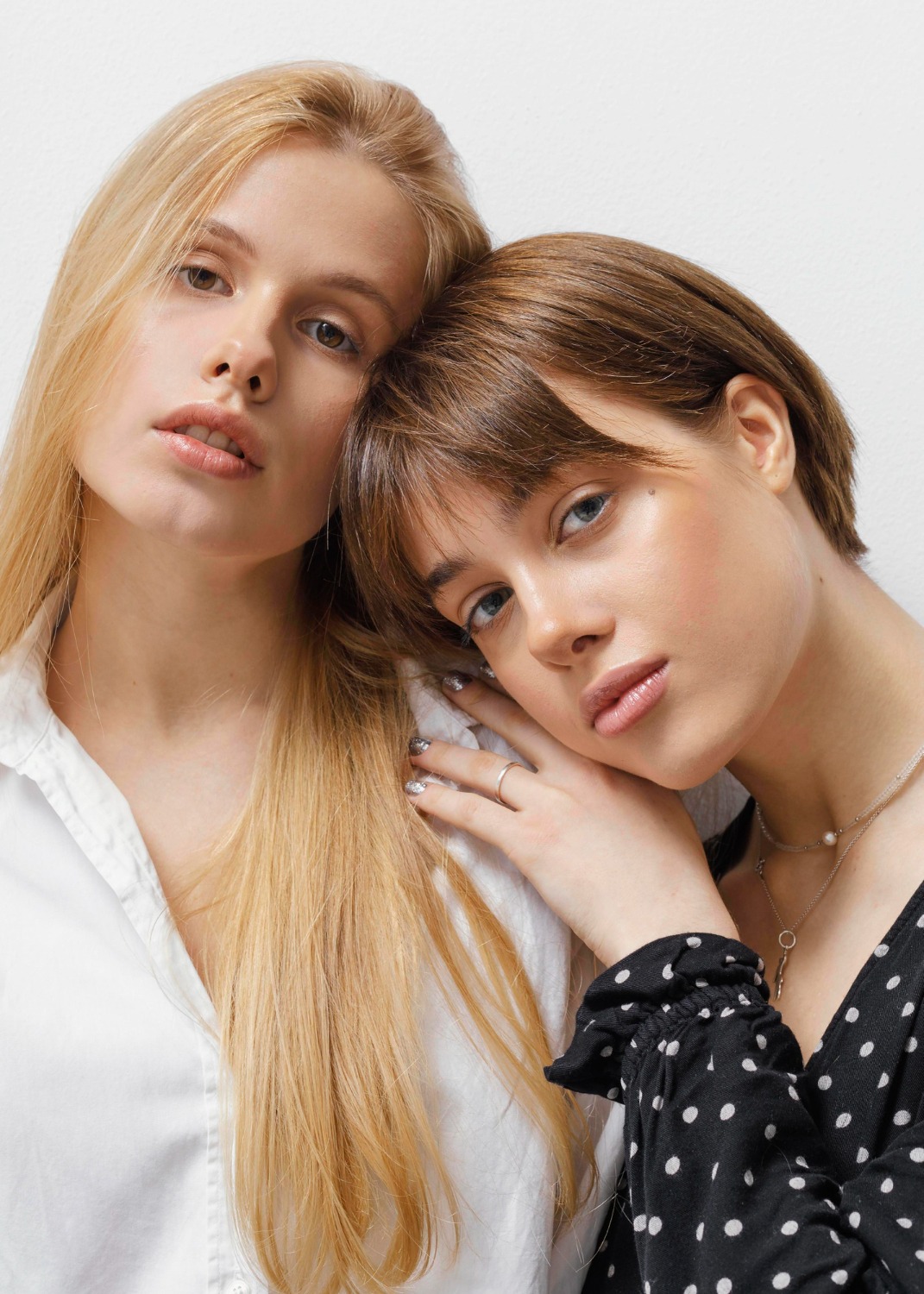 Woman's hands with polished nails in cyan color offering a seashell