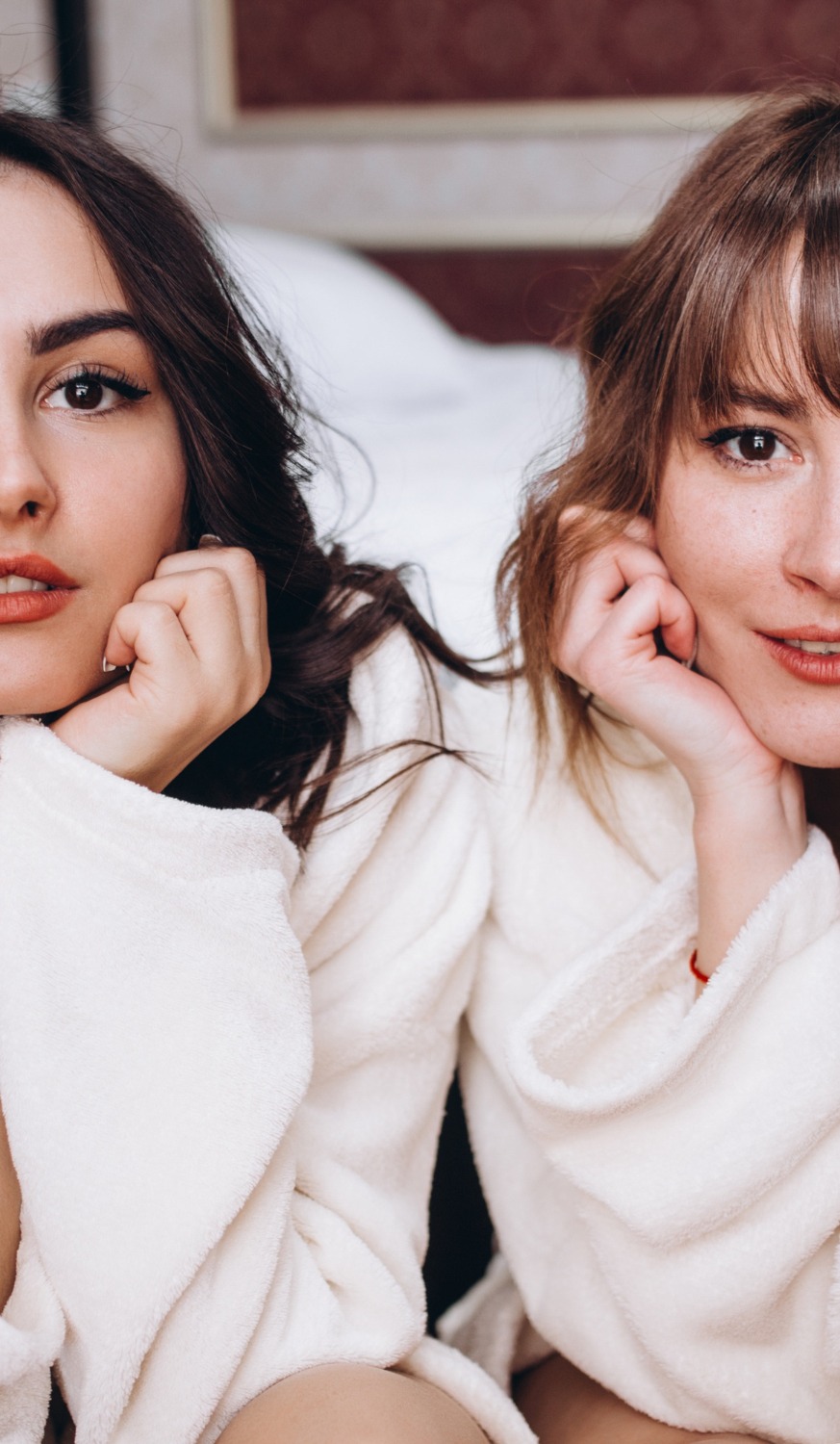 woman's hands with polished nails in coral color on a beach towel